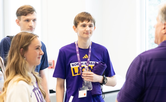 Camden and two other incoming freshman pay close attention to the man speaking with them during a ROAR session.
